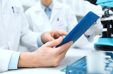 Image showing close up of scientists hands with tablet pc in lab