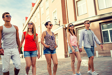 Image showing group of smiling friends walking in the city