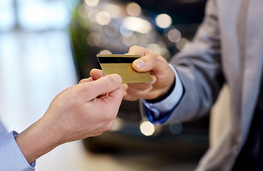 Image showing customer giving credit card to car dealer in salon