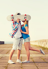 Image showing couple with skateboard kissing outdoors