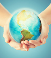 Image showing close up of human hands with earth globe