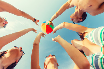 Image showing smiling friends in circle on summer beach