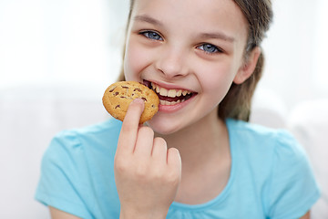 Image showing smiling little girl eating cookie or biscuit