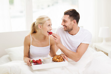 Image showing happy couple having breakfast in bed at home