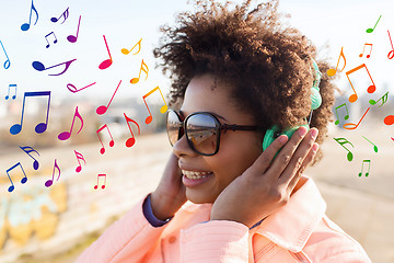 Image showing happy young woman in headphones listening to music