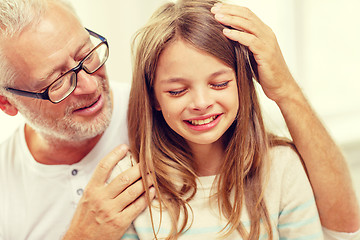 Image showing grandfather with crying granddaughter at home