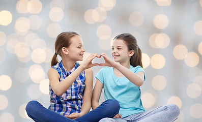 Image showing happy little girls showing heart shape hand sign