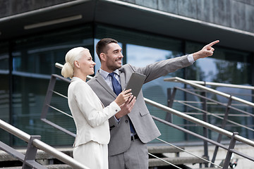 Image showing smiling businessmen with tablet pc outdoors