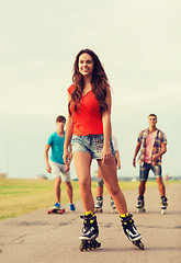 Image showing group of smiling teenagers with roller-skates