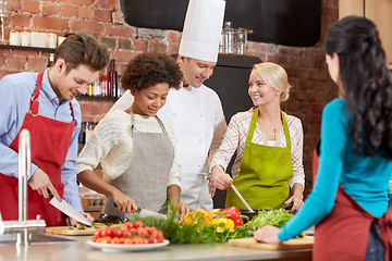 Image showing happy friends and chef cook cooking in kitchen