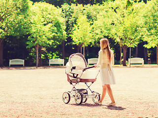 Image showing happy mother with stroller in park