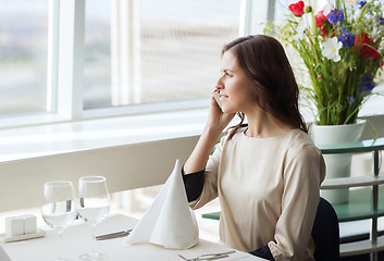 Image showing happy woman calling on smart phone at restaurant