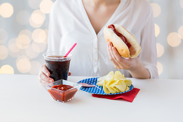 Image showing close up of woman eating hot dog with cola