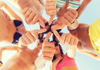 Image showing close up of friends showing thumbs in circle