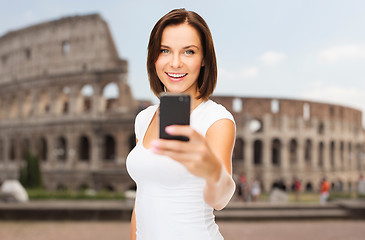 Image showing woman taking selfie with smartphone over coliseum