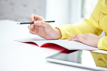 Image showing close up of female hands writing to notebook