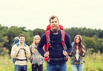 Image showing group of smiling friends with backpacks hiking