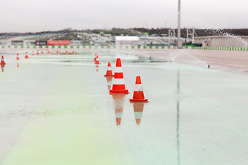 Image showing traffic cones and sprinklers on wet speedway