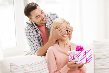 Image showing happy man giving woman gift box at home