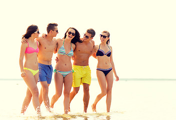 Image showing smiling friends in sunglasses on summer beach