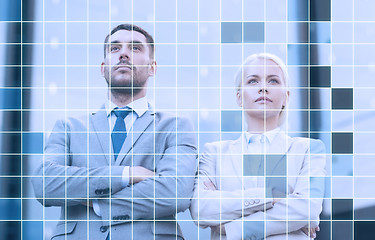 Image showing serious businessmen standing over office building