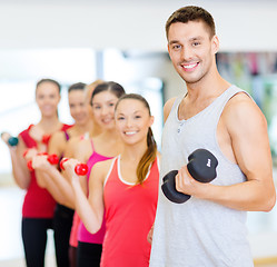 Image showing group of smiling people with dumbbells in the gym