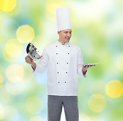 Image showing happy male chef cook opening cloche