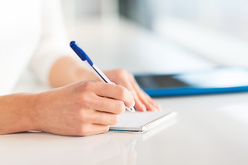 Image showing close up of hands with pen writing to notepad