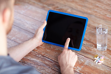 Image showing close up of hands with tablet pc, pills and water