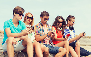 Image showing group of friends with smartphones outdoors