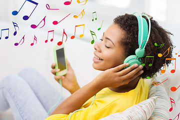 Image showing happy african woman with smartphone and headphones