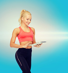 Image showing smiling sporty woman with tablet pc computer