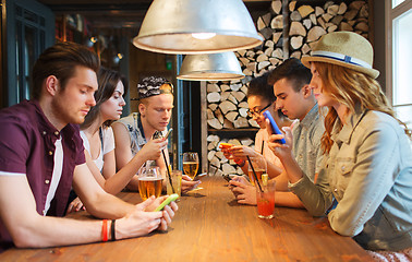 Image showing friends with smartphones and drinks at bar