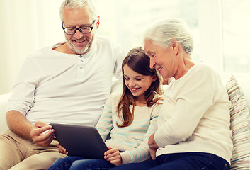 Image showing smiling family with tablet pc at home