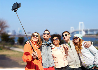 Image showing smiling friends taking selfie with smartphone