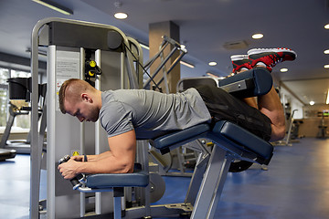 Image showing man flexing leg muscles on gym machine