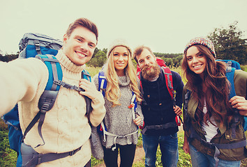 Image showing group of smiling friends with backpacks hiking