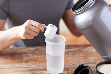 Image showing close up of man with protein shake bottle and jar