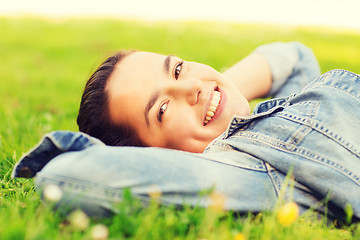 Image showing smiling young girl lying on grass