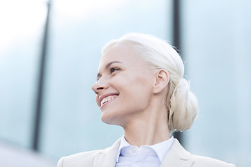 Image showing young smiling businesswoman over office building