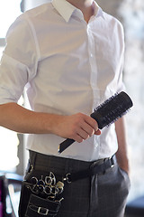 Image showing close up of male stylist with brush at salon