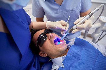 Image showing dentists treating male patient teeth at clinic