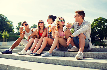 Image showing group of smiling friends sitting on city square