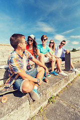 Image showing group of smiling friends sitting on city street