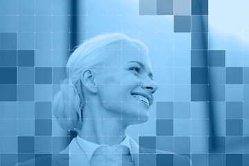 Image showing smiling businesswoman behind monochrome blue grid