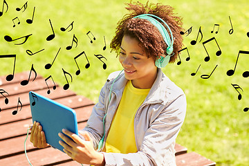 Image showing happy african woman in headphones with tablet pc