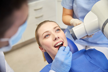 Image showing female patient face with x-ray machine and shield