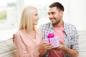 Image showing happy man giving woman gift box at home