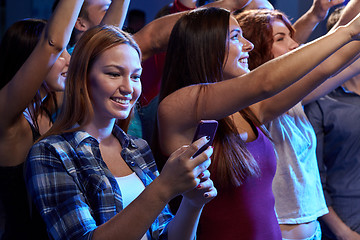Image showing woman with smartphone texting message at concert