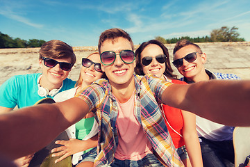 Image showing group of smiling friends making selfie outdoors